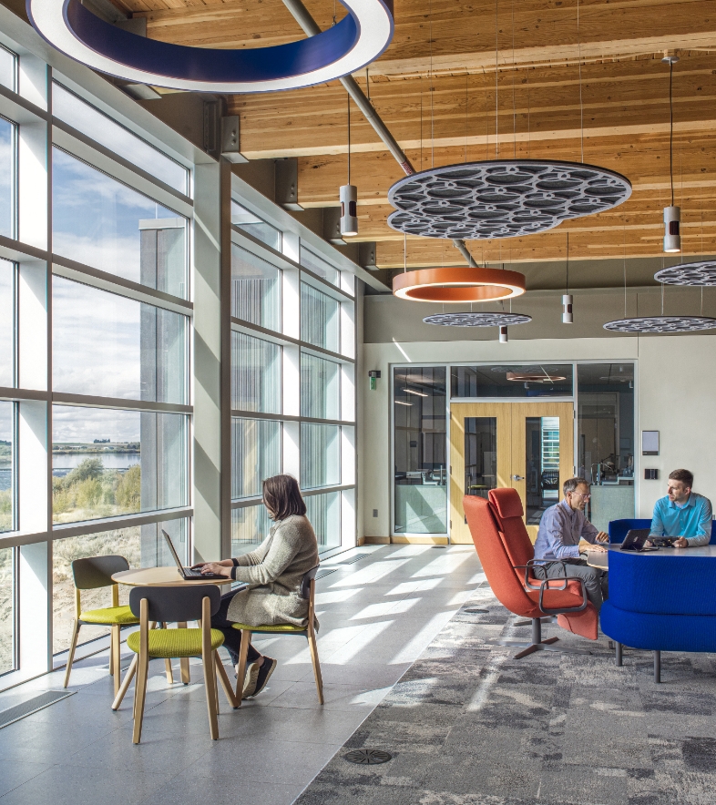 Flad Architects People using an open work area with large windows and views of nature