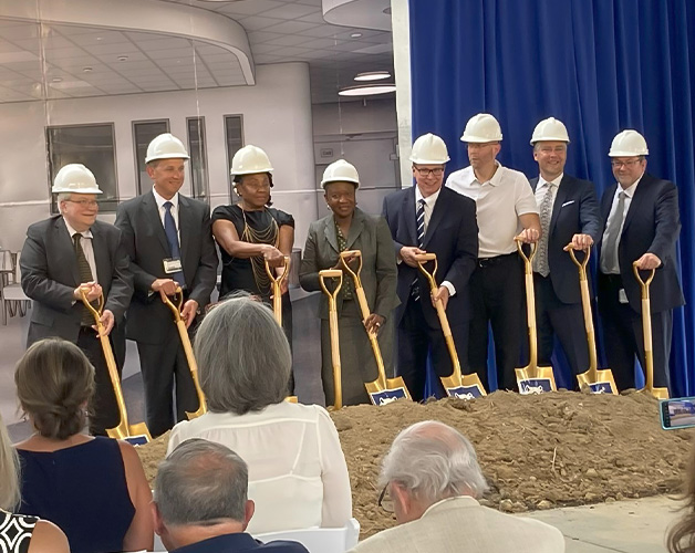 Group photo of hospital leaders and dignitaries scooping dirt at groundbreaking ceremony